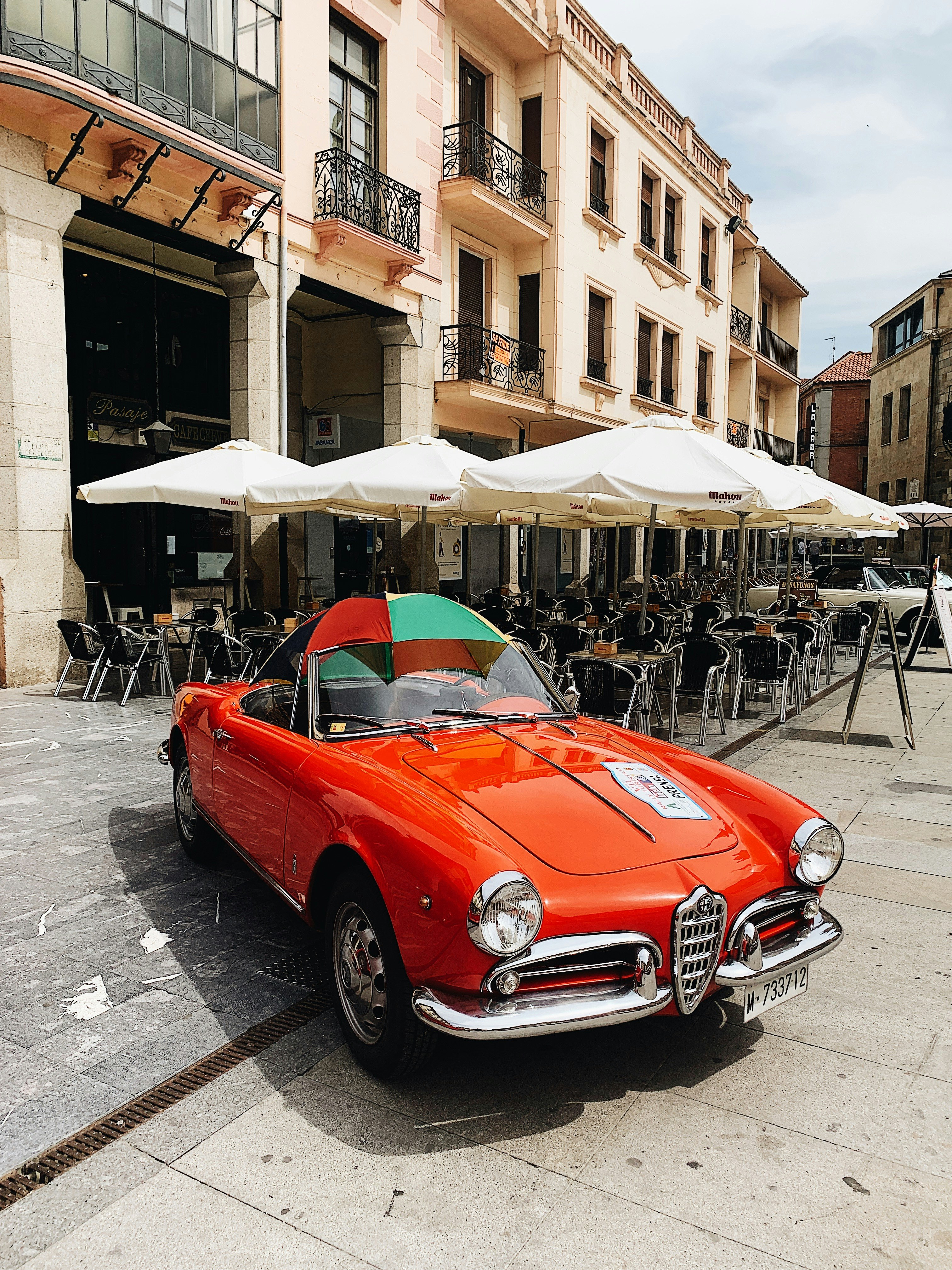 red vehicle parks near parasols